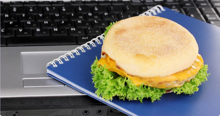 Sandwich on notebook near laptop